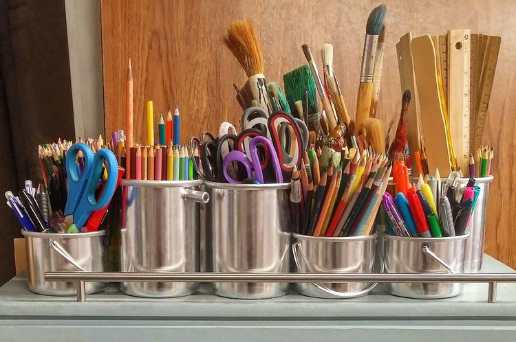 Neatly organized craft supplies on a wooden desk with natural light