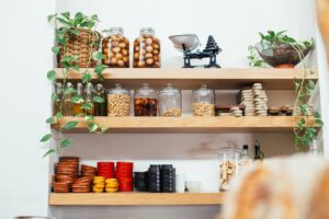 Glass jars filled with colourful craft supplies on a wooden shelf